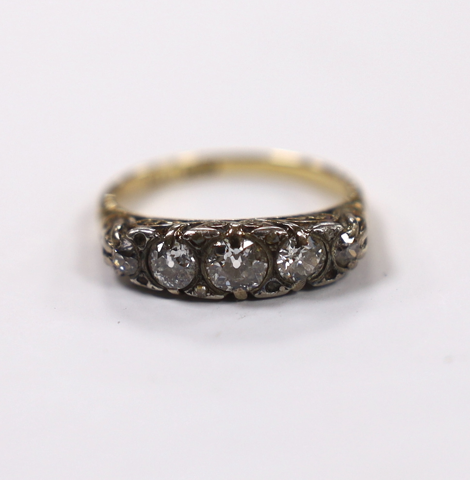An early 20th century 18ct, plat and graduated five stone diamond set half hoop ring, with diamond chip spacers (four missing), size O, gross weight 4.3 grams.